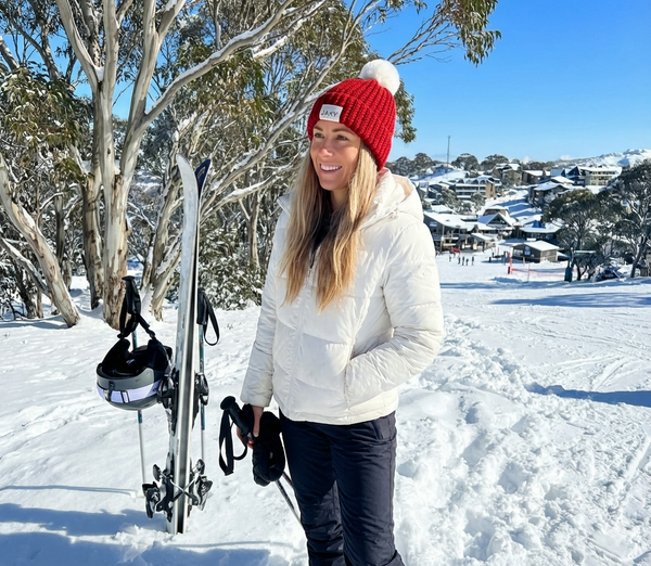 blonde woman wearing scarlet jaxy beanie in snow 