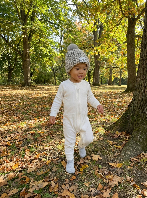 toddler wearing white onesie and marble grey jaxy beanie